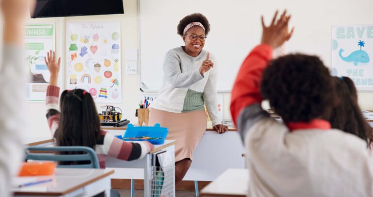 Children, teacher and hands raised at school for questions